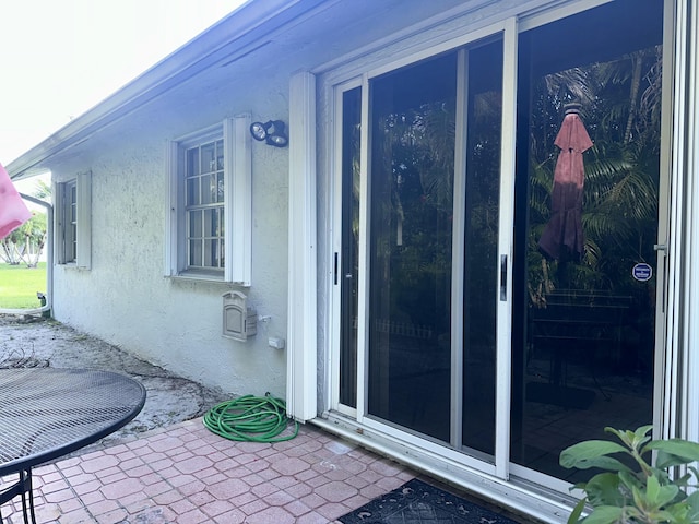 view of side of property featuring a patio and stucco siding