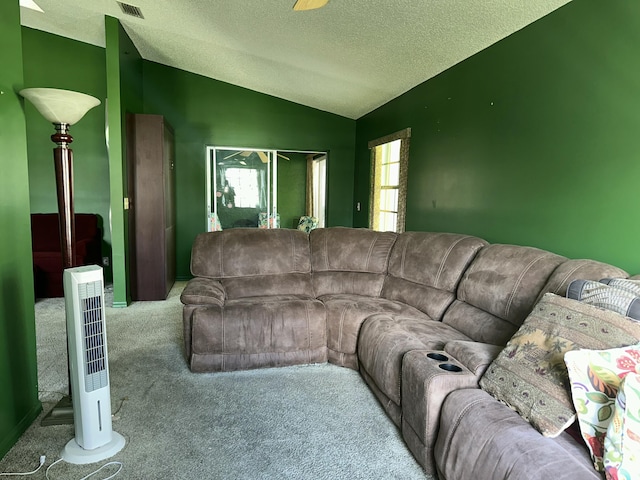 carpeted living room featuring lofted ceiling, visible vents, and a textured ceiling