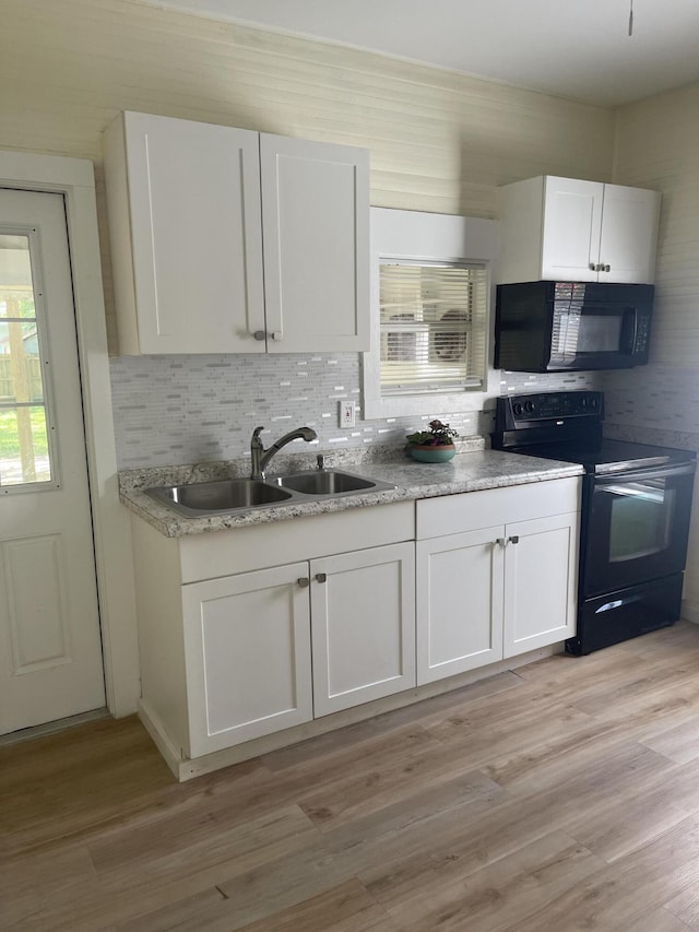 kitchen featuring black appliances, a sink, white cabinetry, and light wood-style floors