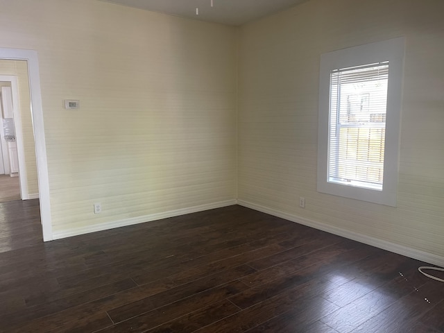 empty room with dark wood-style floors and baseboards