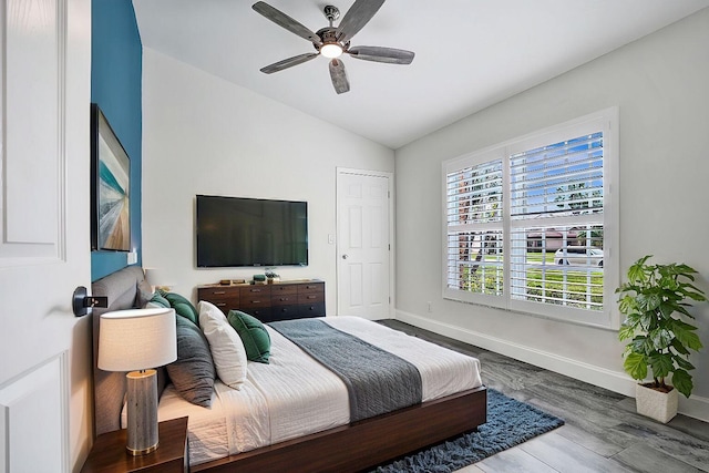 bedroom featuring a ceiling fan, lofted ceiling, and baseboards