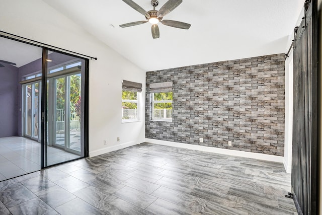 unfurnished room with vaulted ceiling, brick wall, a ceiling fan, and baseboards