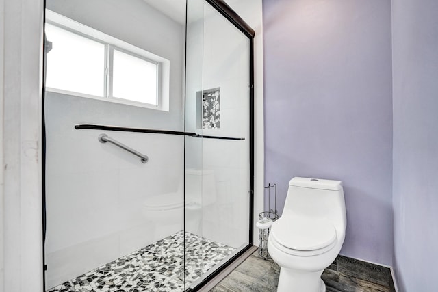 bathroom featuring a shower stall and toilet