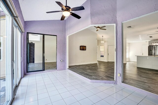 unfurnished room featuring a ceiling fan, tile patterned flooring, visible vents, and a wealth of natural light