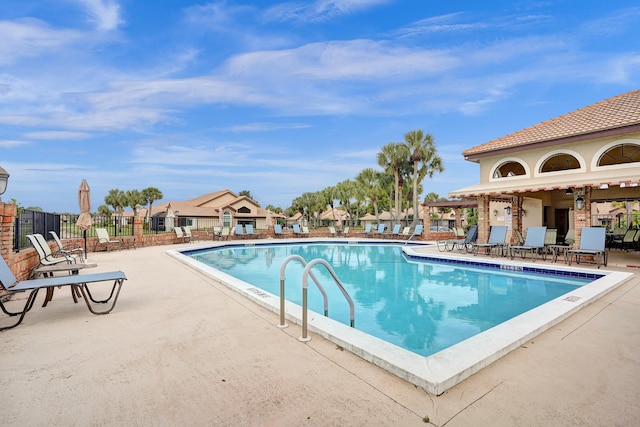 pool with a patio and fence