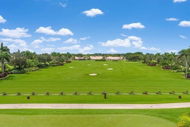 view of home's community featuring view of golf course and a lawn