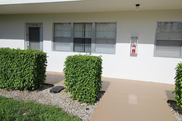 view of exterior entry featuring stucco siding