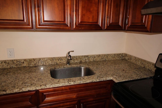 kitchen featuring light stone countertops, electric stove, a sink, and exhaust hood