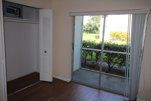 doorway to outside with baseboards and dark wood-style flooring