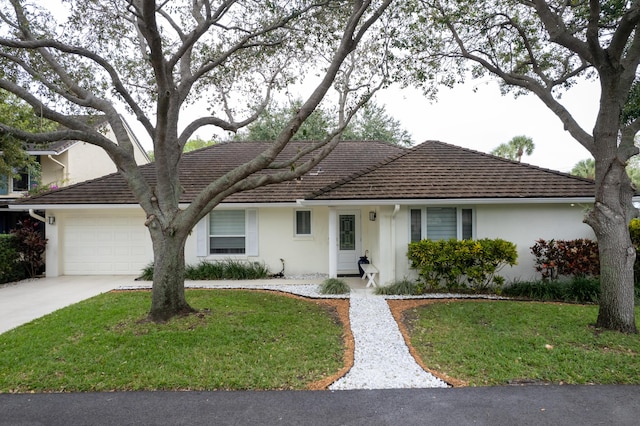 ranch-style house with stucco siding, a garage, and a front yard