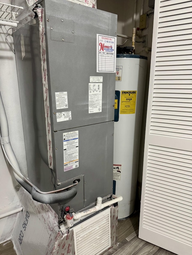 utility room featuring heating unit and gas water heater