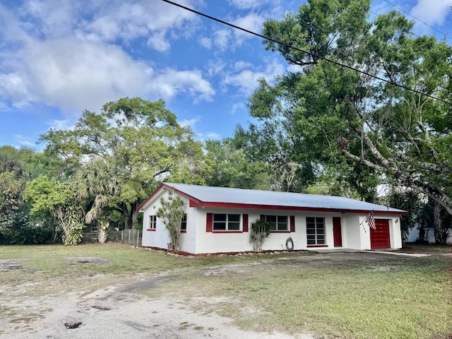 single story home featuring a front lawn, driveway, and an attached garage