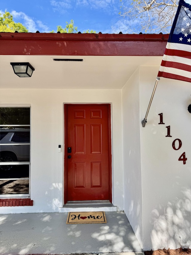 entrance to property featuring stucco siding