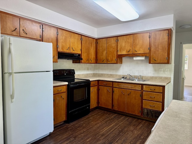 kitchen featuring dark wood finished floors, freestanding refrigerator, black / electric stove, under cabinet range hood, and a sink