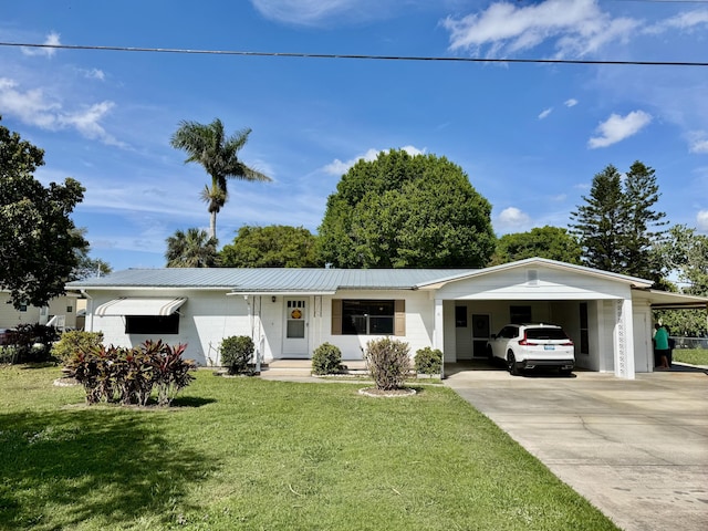 single story home featuring a carport, metal roof, driveway, and a front lawn