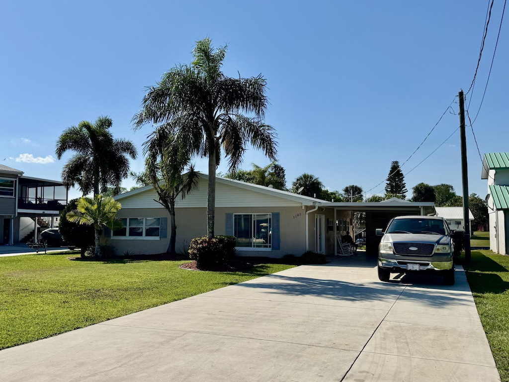 ranch-style house with a front lawn and concrete driveway