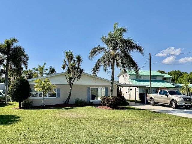 view of front of home with a front lawn, concrete driveway, and stucco siding