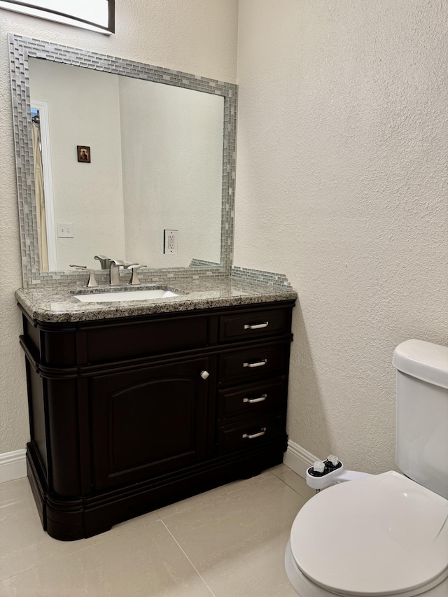 2532 NW 33rd Ave, Okeechobee, FL 34972 - bathroom featuring toilet, baseboards, tile patterned flooring, a textured wall, and vanity