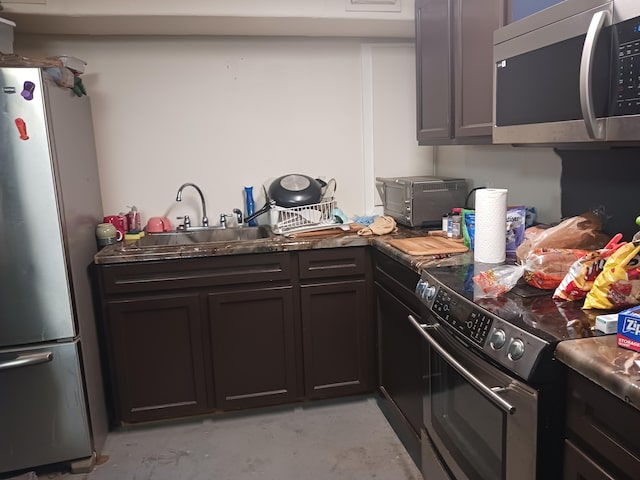 2532 NW 33rd Ave, Okeechobee, FL 34972 - kitchen with a toaster, dark countertops, a sink, unfinished concrete floors, and stainless steel appliances
