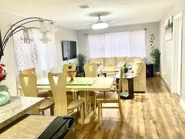 dining room featuring light wood-style floors, ceiling fan, and visible vents