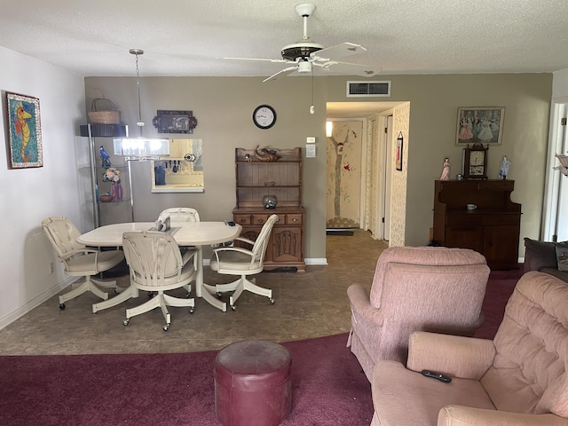 dining space with visible vents, a textured ceiling, and ceiling fan with notable chandelier