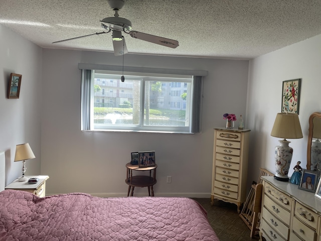 bedroom with multiple windows, a ceiling fan, and a textured ceiling