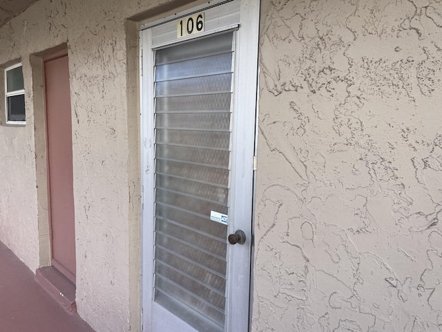 entrance to property featuring stucco siding