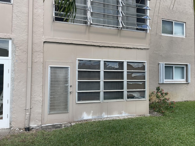 view of side of home with a yard and stucco siding