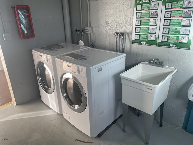 washroom with separate washer and dryer and a sink