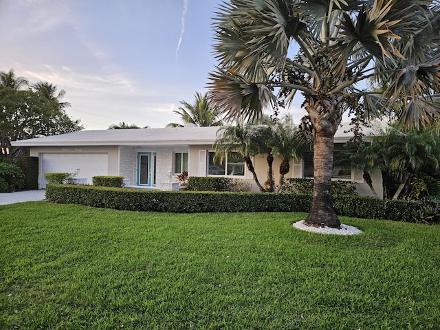 view of front of home with a front yard, an attached garage, and stucco siding