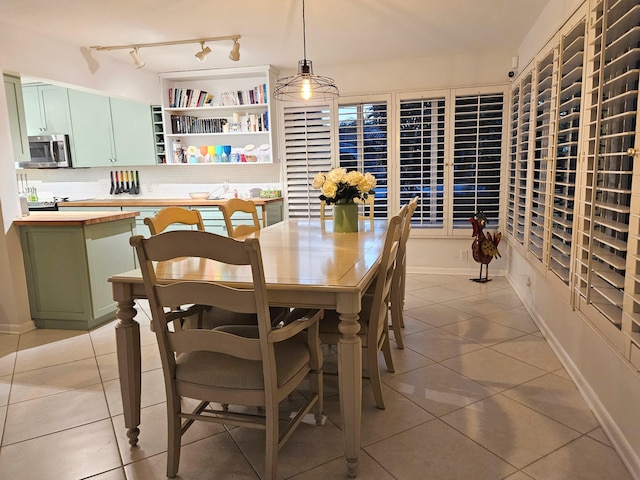 dining area featuring light tile patterned floors and baseboards