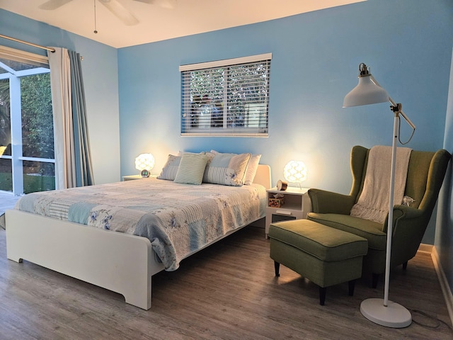 bedroom featuring multiple windows, dark wood finished floors, and a ceiling fan