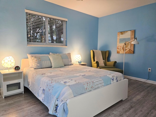 bedroom with baseboards and dark wood-style flooring