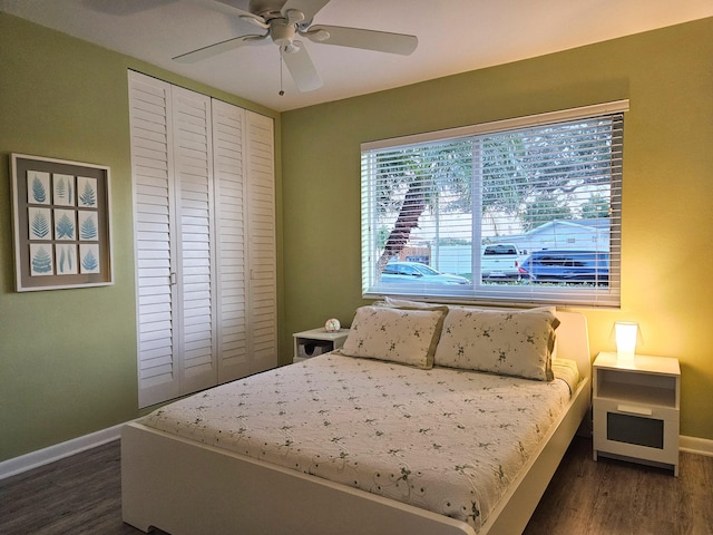 bedroom featuring a closet, dark wood finished floors, a ceiling fan, and baseboards