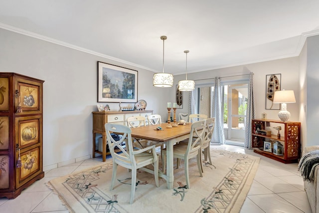 dining area with light tile patterned floors, ornamental molding, and baseboards