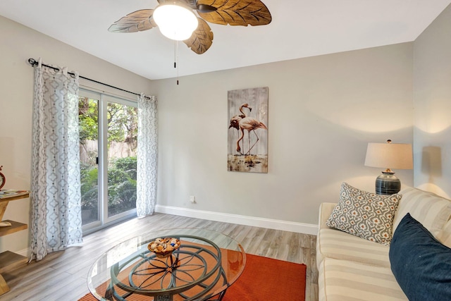 living room with ceiling fan, wood finished floors, and baseboards