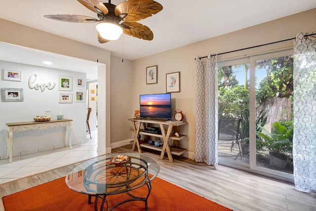 living area with ceiling fan, baseboards, and wood finished floors