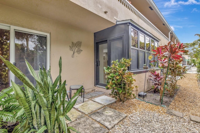 doorway to property featuring a patio and stucco siding