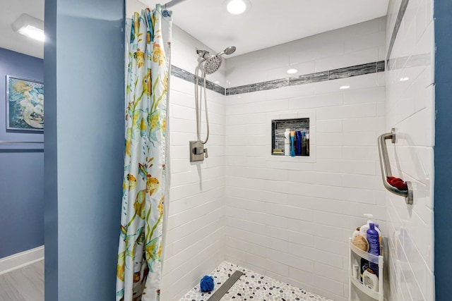 bathroom with a stall shower and baseboards