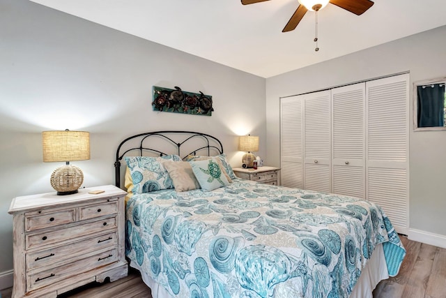 bedroom with a ceiling fan, a closet, baseboards, and wood finished floors