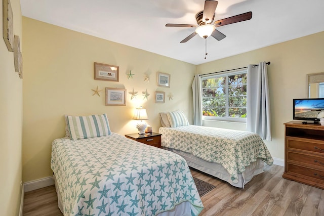 bedroom featuring a ceiling fan, baseboards, and wood finished floors