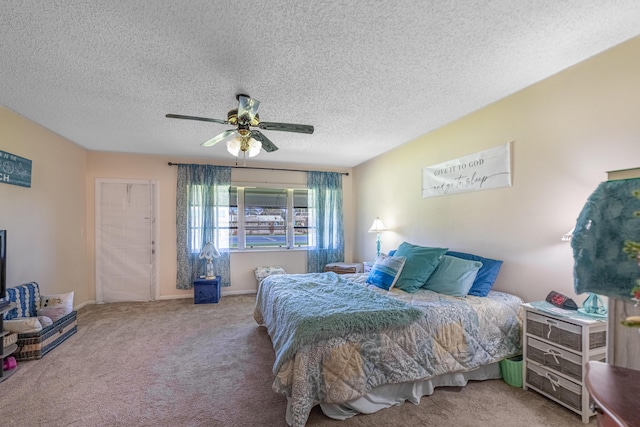 bedroom with a textured ceiling, carpet flooring, and a ceiling fan