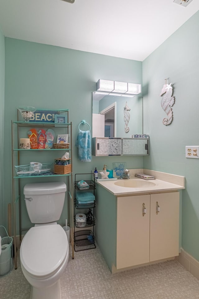 half bathroom with visible vents, vanity, and toilet