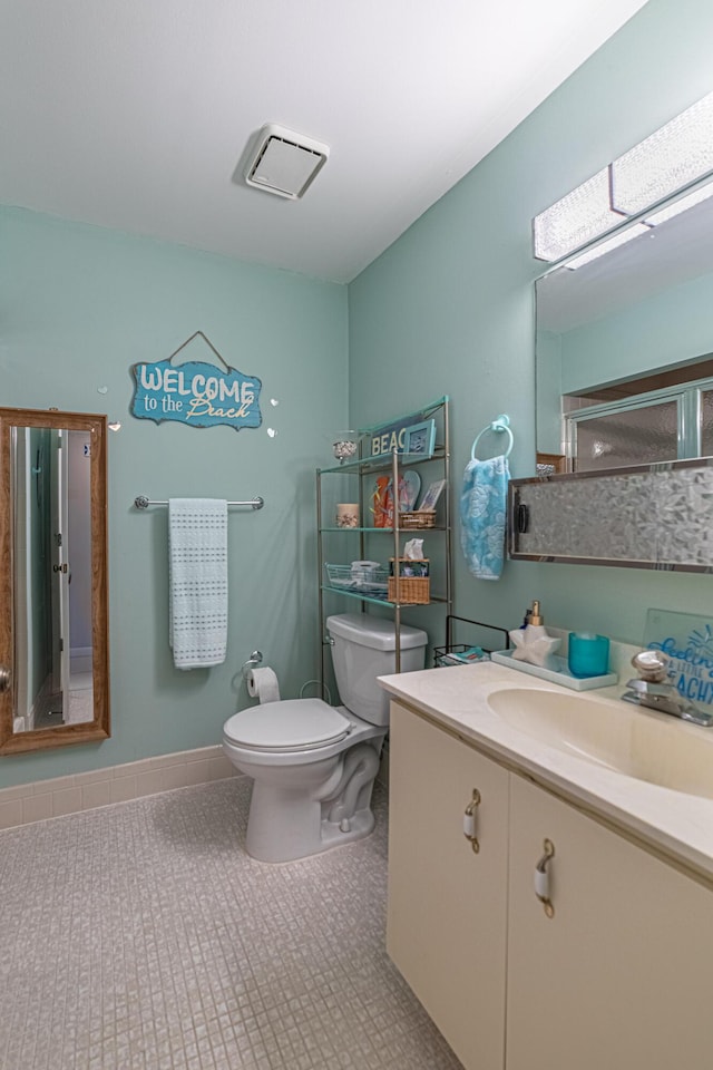 bathroom featuring vanity, tile patterned flooring, and toilet