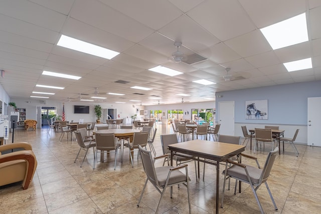 dining space with ceiling fan and a paneled ceiling