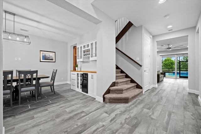 dining space featuring wine cooler, visible vents, a dry bar, and wood finished floors