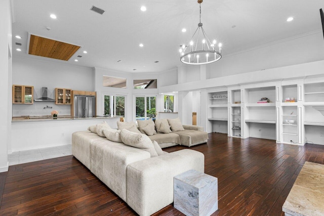 living area with dark wood-style floors, visible vents, a notable chandelier, and crown molding