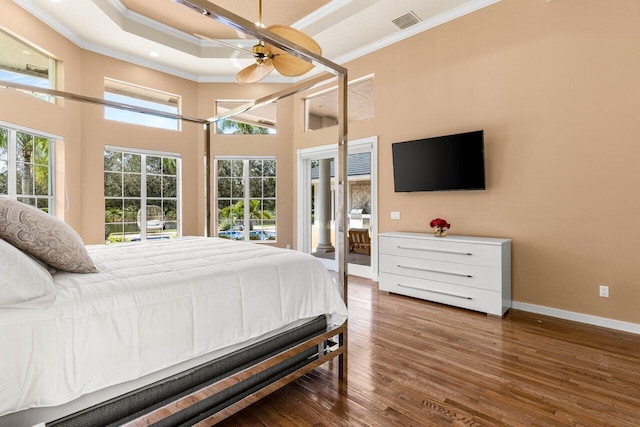 bedroom featuring visible vents, baseboards, a towering ceiling, dark wood-type flooring, and crown molding