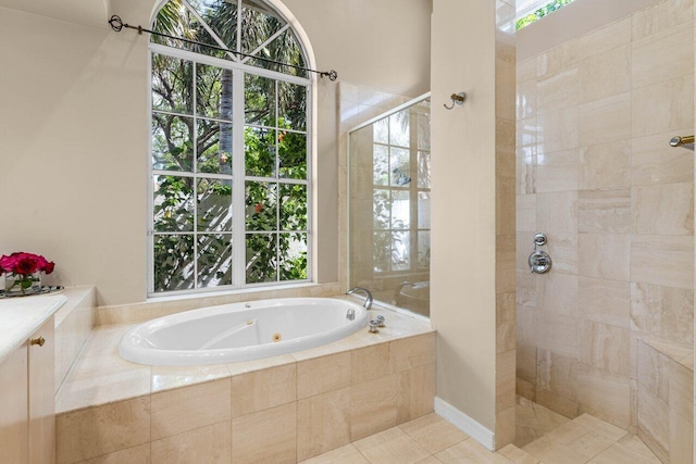 full bathroom featuring a whirlpool tub, plenty of natural light, a tile shower, and tile patterned floors