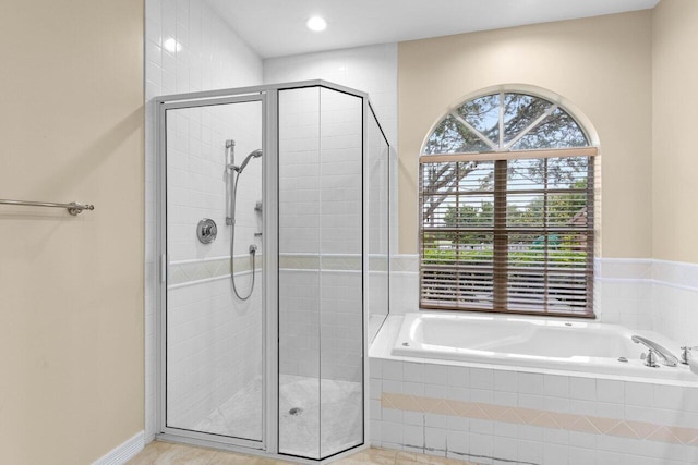 full bathroom featuring a stall shower and a garden tub